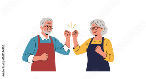 Happy elderly man and woman in aprons celebrating with a friendly fist bump representing partnership and successful cooperation.