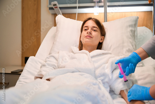 Cuadro en lienzo Female patient lying in hospital bed while nurse administers injection