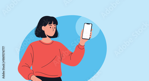 Smiling woman in a bright red sweater holds up a modern smartphone with a blank white screen for copy space against a simple blue circular backdrop.