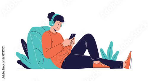 Relaxed person in an orange sweater and headphones sits on the ground leaning back against a leaf-shaped cushion while looking at their smartphone.