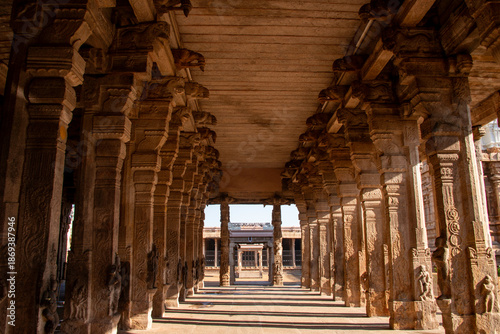 Stone corridor with sculpted pillars alongside at SriRangam Temple in India. 