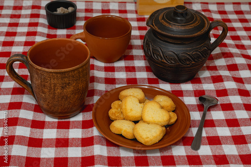 Heart-shaped cookies on a plate and tea utensils
