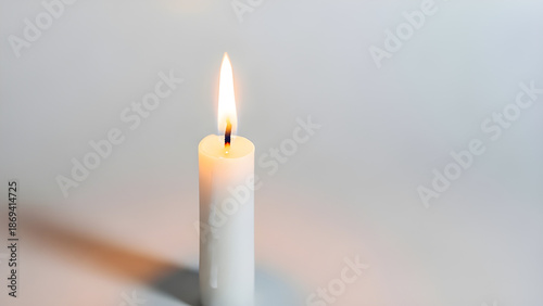 A burning candle with a soft, warm glow