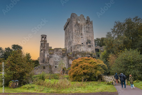 The exterior of Blarney Castle, a medieval stronghold in Cork, Ireland, captured in autumn under a moody sunset sky