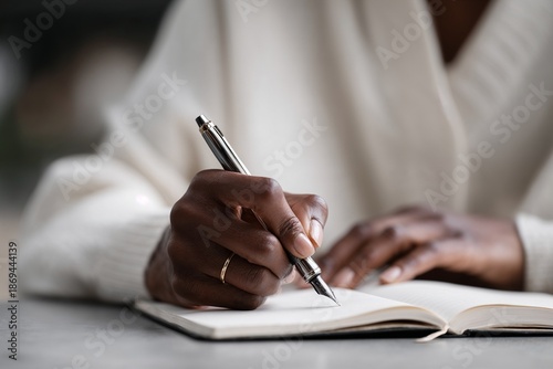 Close-up of hand writing in notebook with fountain pen