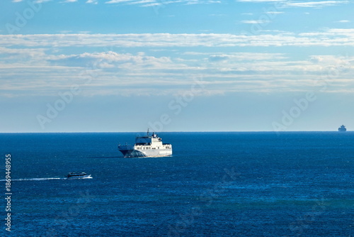 Aliscafo in viaggio con nave passeggeri e nave mercantile ancorate e in alto mare