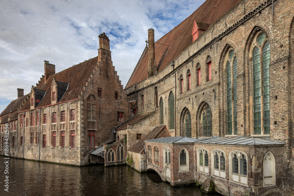 Obraz premium View from Mary's Bridge (Mariabrug) of Saint John’s Hospital (Museum Sint-Janshospitaal) and medieval buildings in Bruges, Belgium