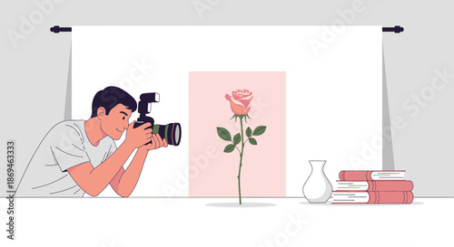 Young male photographer taking a still life photo of a single rose.
