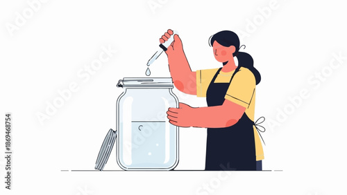 Person in apron adding liquid to large jar using dropper