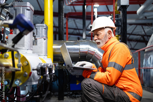 Photography Senior engineer working on laptop at industrial plant