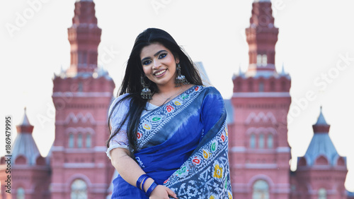 Bangladeshi girl smiling in Moscow, wearing a saree in front of a landmark building