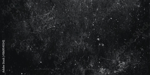 A monochromatic texture displaying a distressed grainy surface with scattered light imperfections and dark shadows