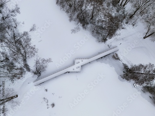 Aerial View of Snow-Covered Wooden Bridge Over Frozen Lake