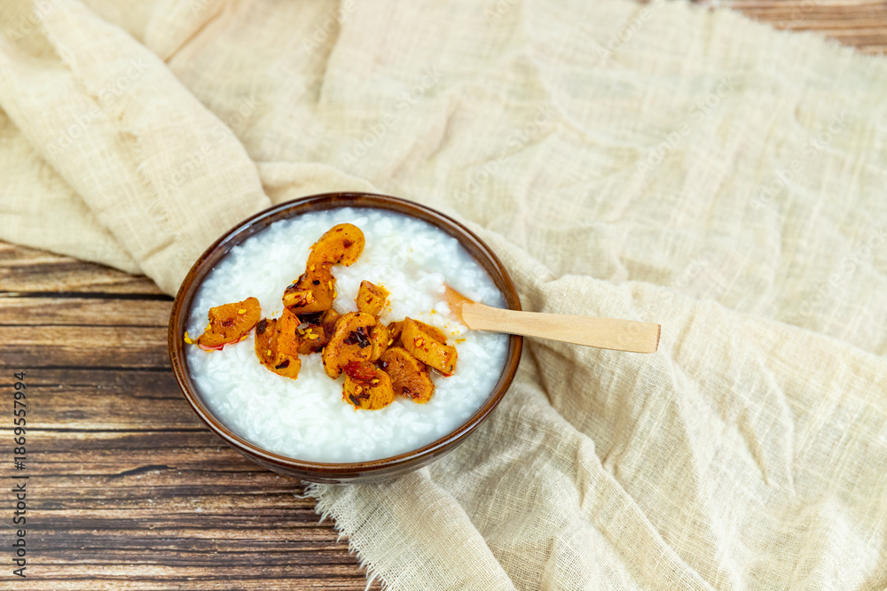 Fototapeta premium The white rice porridge and red oil dried radish in the porcelain bowl