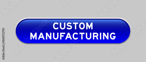 Blue color capsule shape button with word custom manufacturing on gray background