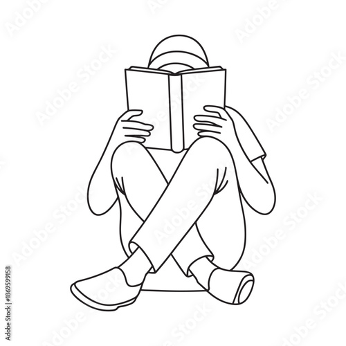 A person engrossed in reading a book sitting cross legged on the floor