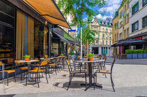 Фотография Street restaurant with tables and chairs on pedestrian street in old town Ville