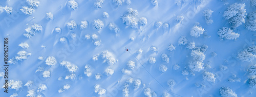 Cuadro en lienzo Top down aerial view of a ski mountaineer crossing a pristine winter landscape