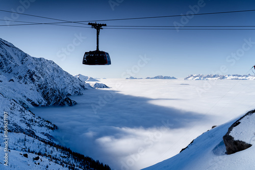 Billede på lærred Cable car on backdrop of high mountains is running to summit of the Aiguille du Midi in winter, Chamonix-Mont-Blanc, French Alps
