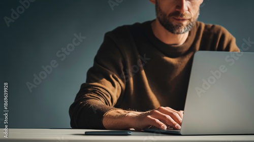 man working on laptop, on dark grey background