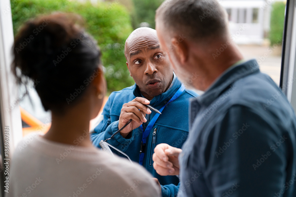Fototapeta premium Man speaks to couple at their door in a residential area during daytime