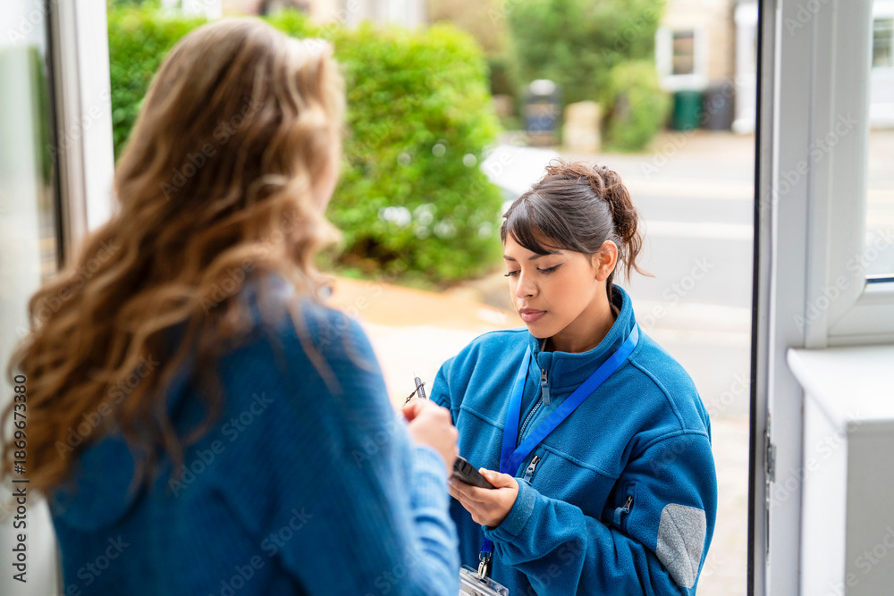 Fototapeta premium Postal worker talks to a resident while delivering mail in a neighborhood