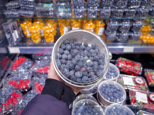 buying fruits and  berries ( raspberries, blueberries, strawberries, gooseberries)at the market
