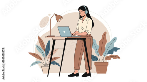 Woman working on laptop at standing desk with headphones and plants