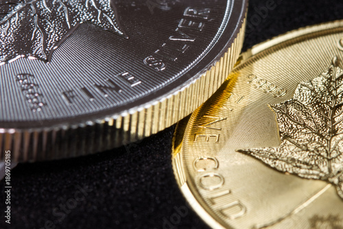 Close-up of the inscription “fine silver” on a silver coin lying on a gold coin labeled “fine gold,” representing precious metal prices and the gold-to-silver ratio.