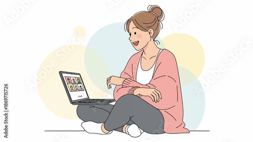 Young woman video calling friends on laptop, sitting cross-legged, cheerful communication