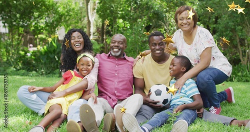 Photos Sitting extended family wearing casual clothes on lawn, holding soccer ball, sho