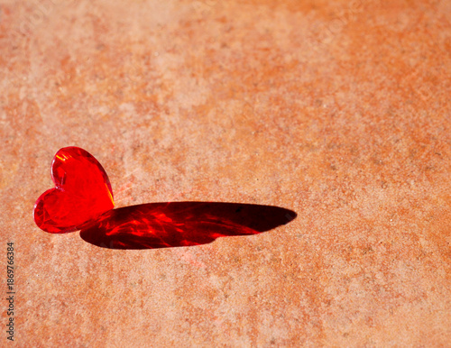 Quadro su tela a red heart casting a red shadow on the floor