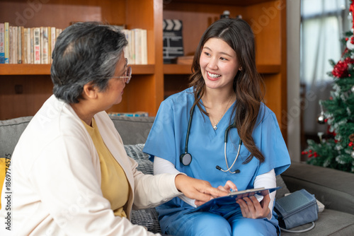 Nursing home, Asian woman or doctor with clipboard writing medical problem of elderly woman patient. Healthcare, tech and nurse caregiver help consulting with senior retirement in living room at home.