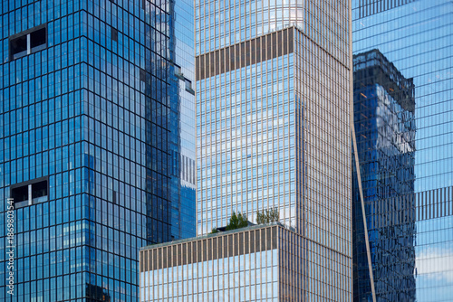 Low-angle view of modern skyscrapers in Manhattan, New York City. This dramatic perspective emphasizes the towering height and sleek design of the city's contemporary architecture.
