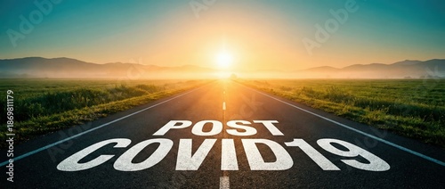 Scenic straight road stretching toward a bright golden sunrise in a misty green landscape, symbolizing a hopeful future with POST COVID19 text painted on the asphalt at dawn.