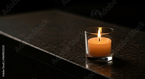 A silent memorial flame burning with a warm glow on a dark granite surface, representing a solemn remembrance and peace concept for the Day of Remembrance for Genocide Victims