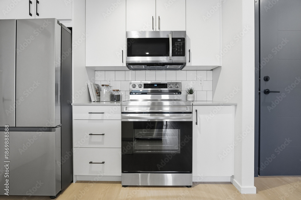 Fototapeta premium Silver stove with a black oven sits in a kitchen
