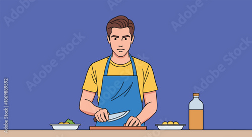 Serious young man wearing a blue apron carefully chopping ingredients with a knife on a wooden board at a kitchen counter.