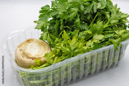 Fresh parsley with celery root closeup on white.