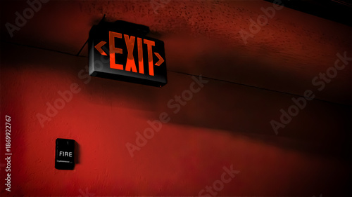 A glowing EXIT sign and a black fire alarm pull. Evacuation and emergency preparedness concept. training illustration background banner with copy space.
