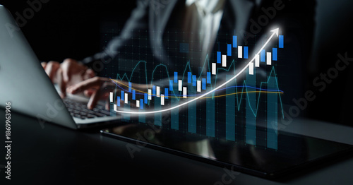 Canvas Print A dedicated business professional focusing on financial market trends while using a laptop in a modern office, showcasing data-driven analysis with innovative graphs