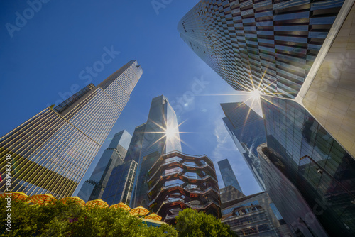 The illuminated Vessel at Hudson Yards against New York City's modern skyscrapers. A must-visit architectural marvel.