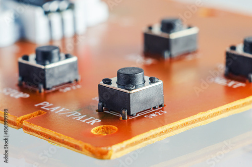 Fotografie Close-up view of tactile push buttons on a printed circuit board with labels lik