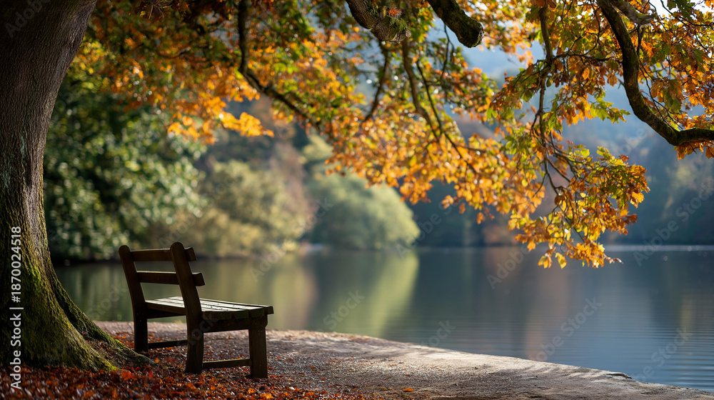 Naklejka premium Peaceful lakeside scene with empty wooden bench surrounded by vibrant autumn leaves and trees reflecting in calm water, seasonal tranquility, with copy space