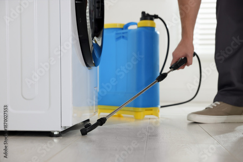 Cuadro en lienzo Pest control worker spraying insecticide indoors, closeup