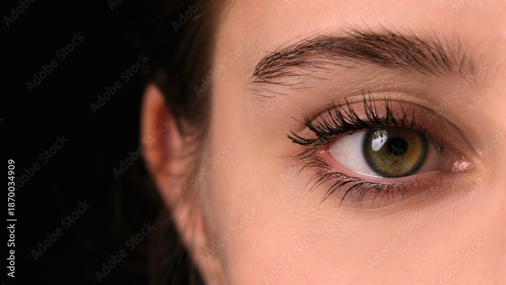 Obraz premium Girl Widely Opens Her Large Green Eye For A Close-Up View