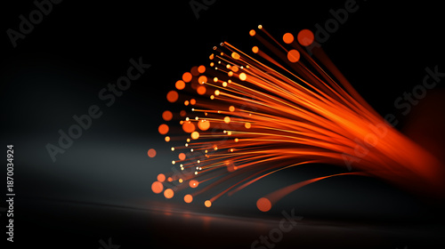 Fiber optic cables glowing orange with light particles on dark background, internet connectivity and data transmission concept