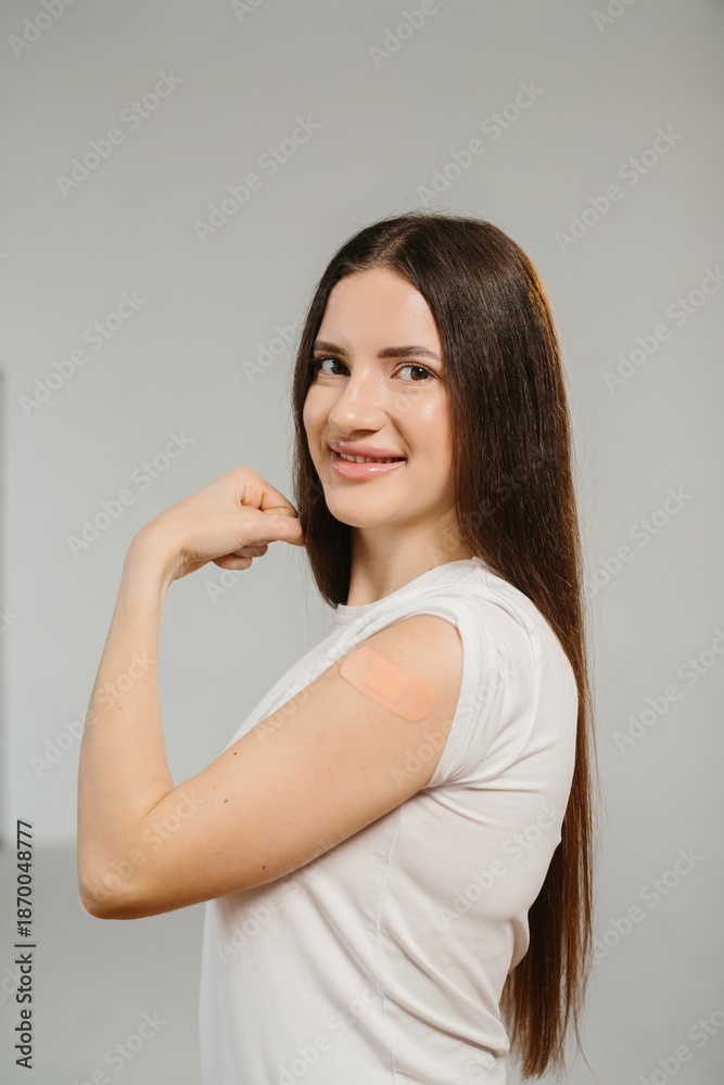 Fototapeta premium Woman showing arm with vaccination bandage feeling strong protection