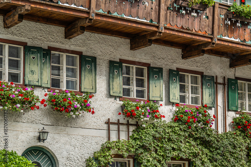 Tableau sur toile Alpine house facade with wooden shutters and flower boxes
