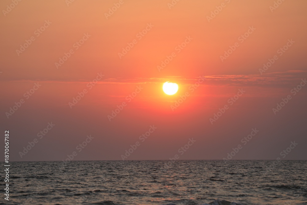 Obraz premium Picturesque sky with sun over sea at sunset